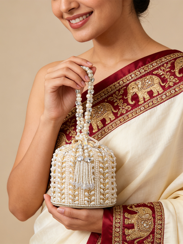 Rubans Off White Coloured Potli Bag With Golden Embroided Design And Pearls.
