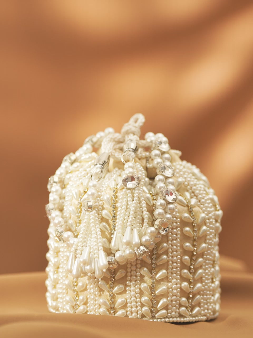 Rubans Off White Coloured Potli Bag With Golden Embroided Design And Pearls.