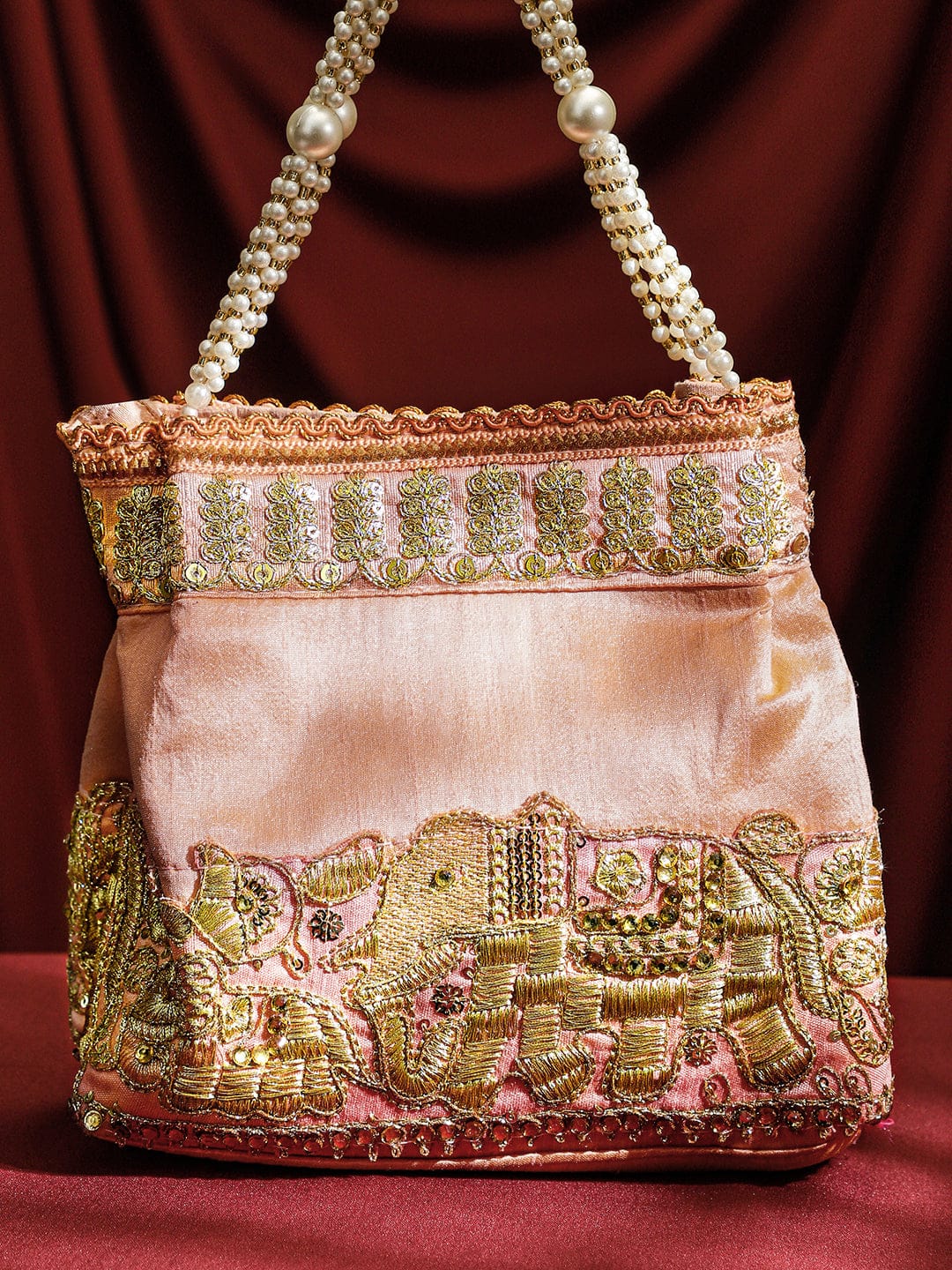 Rubans Handcrafted Peach Pink Silk Potli Bag with Pearl Handle & Gold Embroidered Elephant Motif Bags